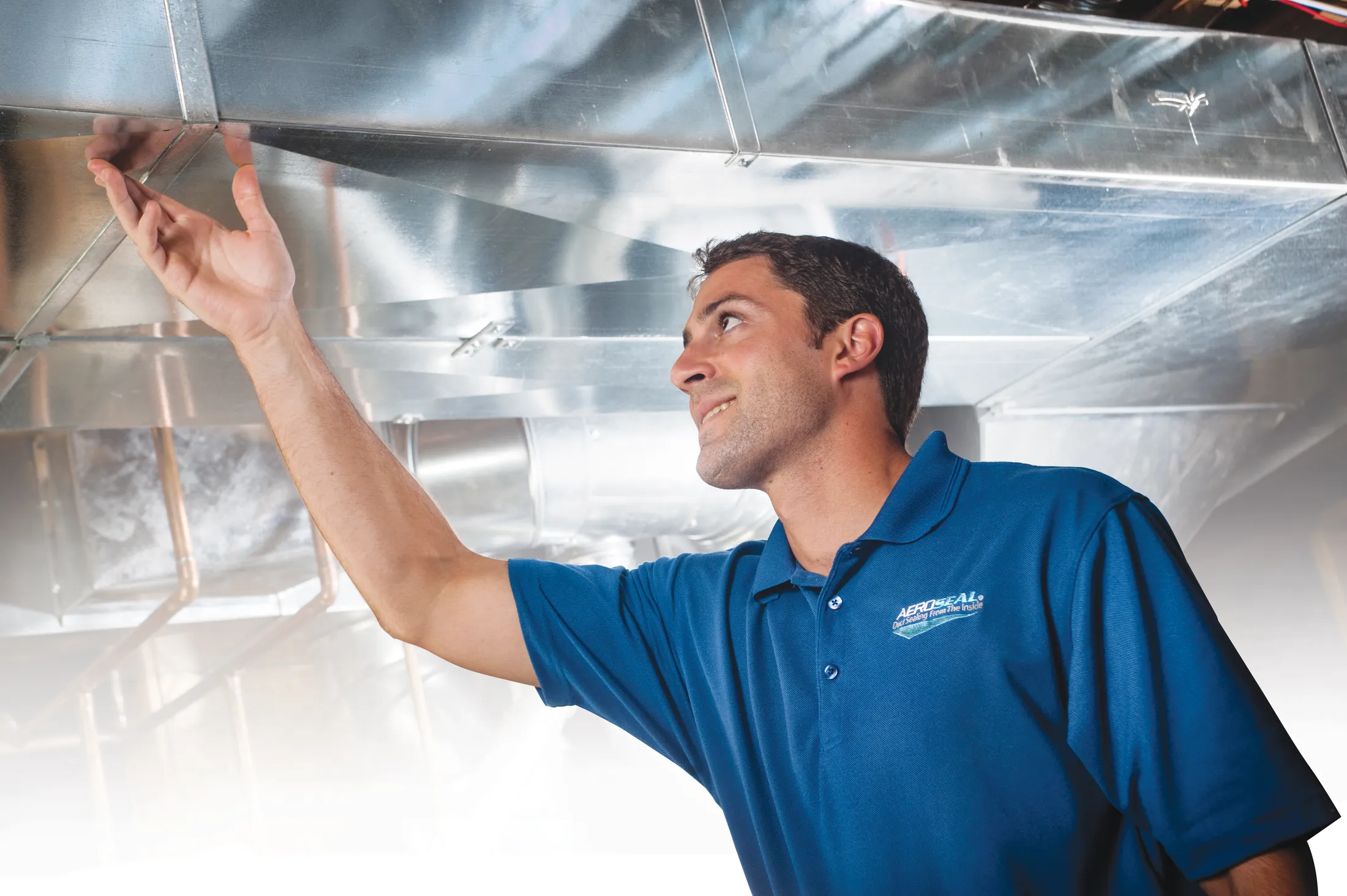 Technician inspecting HVAC equipment during Aeroseal duct evaluation