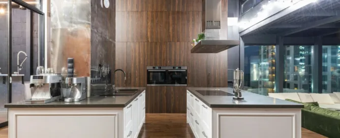 Modern kitchen with two white islands, wood and metallic accents, and city views.